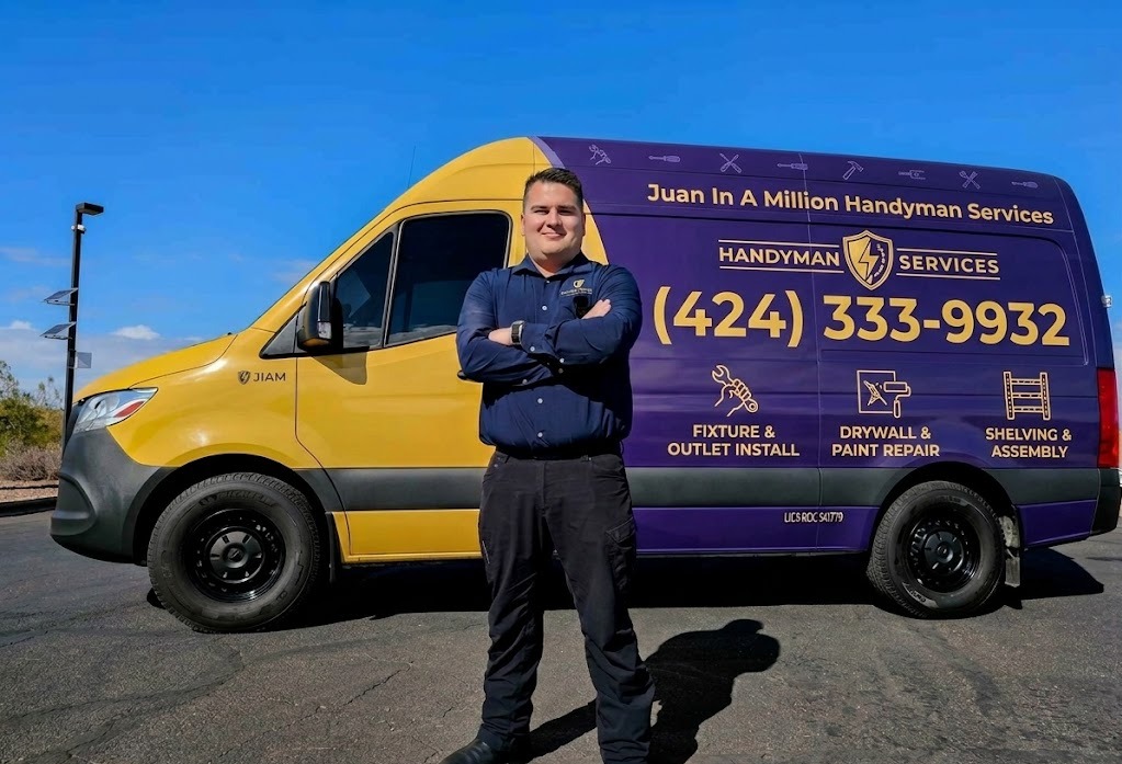 Handyman standing with arms crossed in front of a branded purple and yellow Juan In A Million Handyman Services van